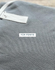 Grey mesh fabric of an organic cotton fly sheet with a light-coloured binding, for ponies