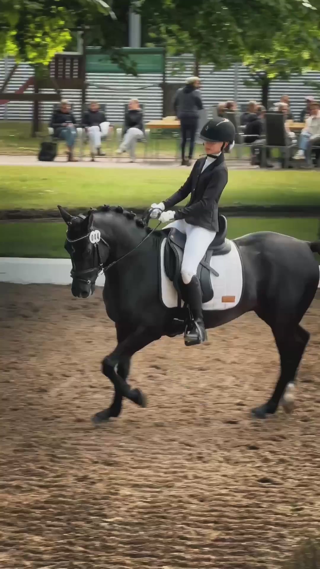 Junge Reiterin auf schwarzem Pony in einer Dressurprüfung, weiße Dressurschabracke Relief für Ponys mit CHVX*N Lederpatch